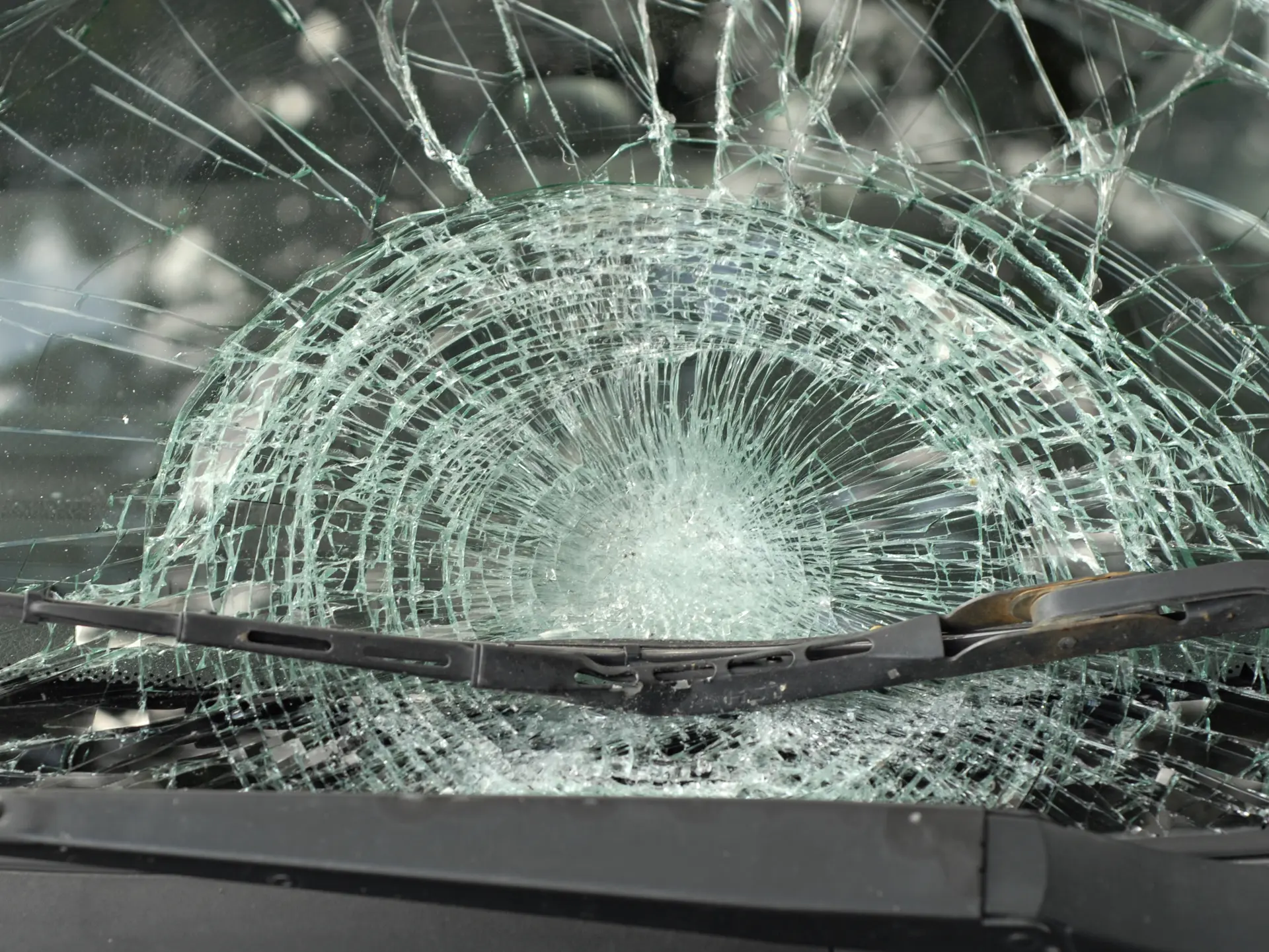 Severely shattered windscreen with wiper blade visible